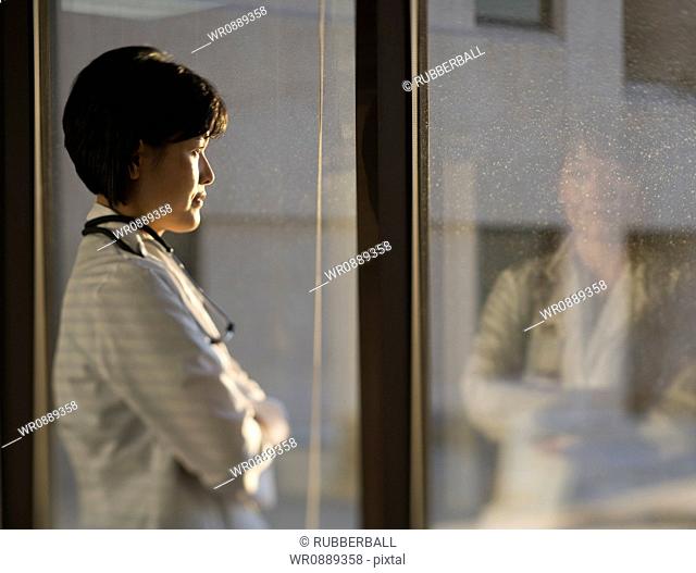 Profile of a female doctor looking through a window