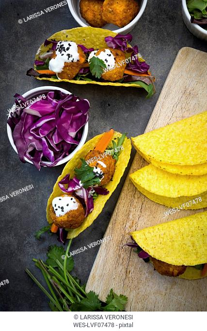 Sweet potato falafel in taco shells, with red cabbage, salad, carrot, yogurt sauce and black sesame
