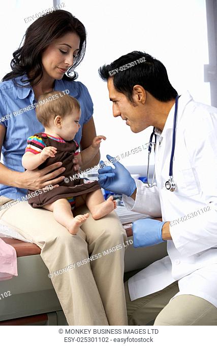 Doctor In Surgery Examining Baby Girl