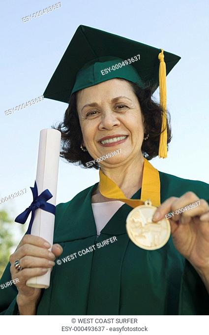 Senior Graduate holding diploma and medal outside portrait