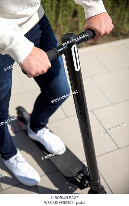 Close-up of man using e-scooter in the city