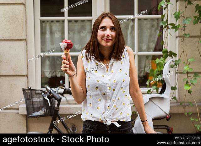 Smiling young woman with ice cream on nose