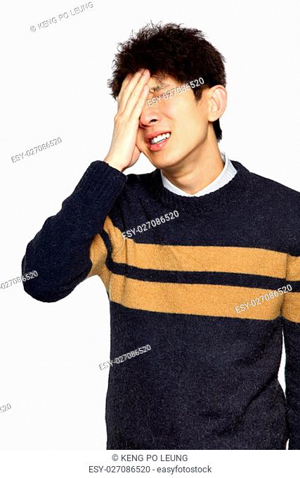Closeup portrait, stressed young asian man, hands on head with bad headache, isolated background on white. Negative human emotion facial expression feelings