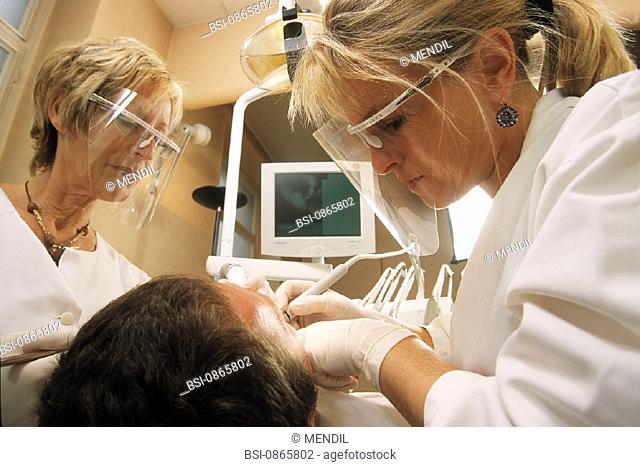MAN RECEIVING DENTAL CARE<BR>Photo essay from dental office with dentist, dental assistant, and model. Model release