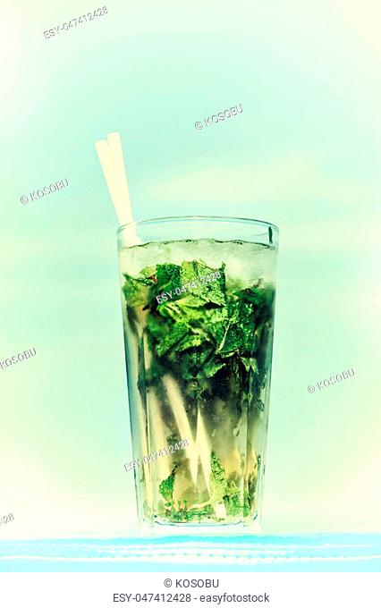 One misted glass of cocktail mojito over blue sky background