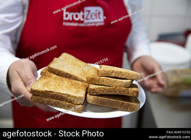 Helper carries a plate of toast, The Brotzeit project is intended to enable children to start the school day with breakfast, Actress Uschi GLAS