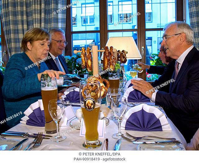 dpatop - German Chancellor Angela Merkel (CDU, l) attends a dinner with former German finance minister Theo Waigel (CSU, r) after her visit to the conference of...