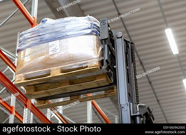 forklift loader loading cargo to warehouse shelves