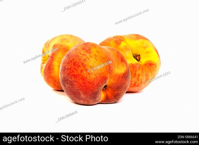 Three perfect, ripe peaches isolated on a white background