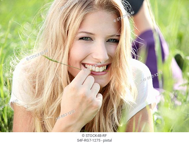 Happy young woman lying in meadow