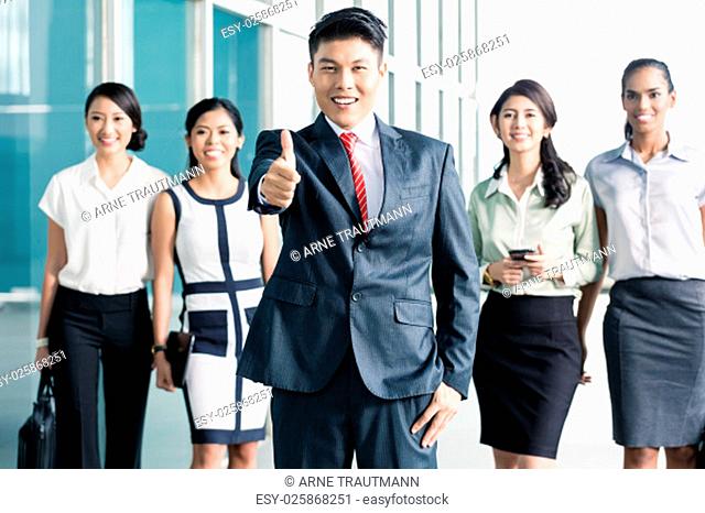 Bank staff in front of Asian office showing thumbs up, men and women of Chinese, Indonesian, and Indian ethnicity