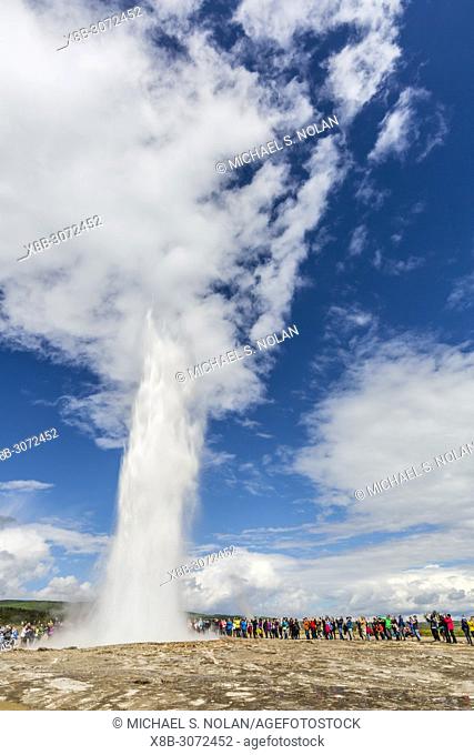Tourists gather to watch Strokker geyser, ""geysir"", an erupting spring at Haukadalur, Iceland