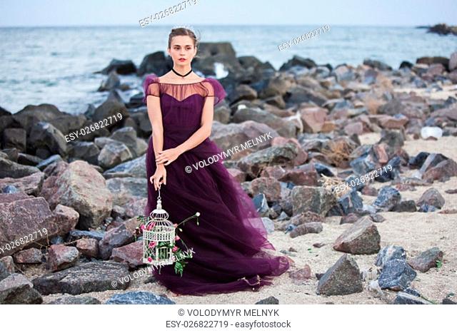 The wedding day at the sea. Young romantic woman posing on the beach watching the sunset
