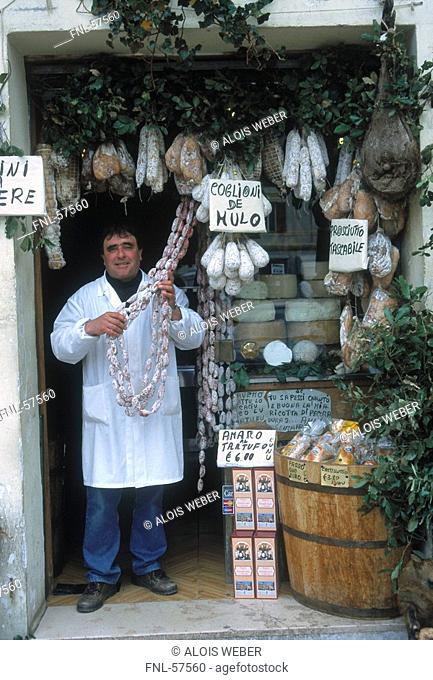 Shopkeeper standing in butcher shop, Norcia, Umbria, Italy