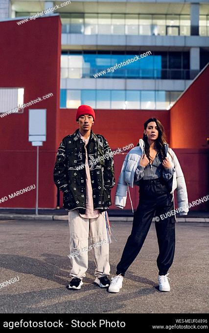 Multiracial couple with casual clothing standing in front of building