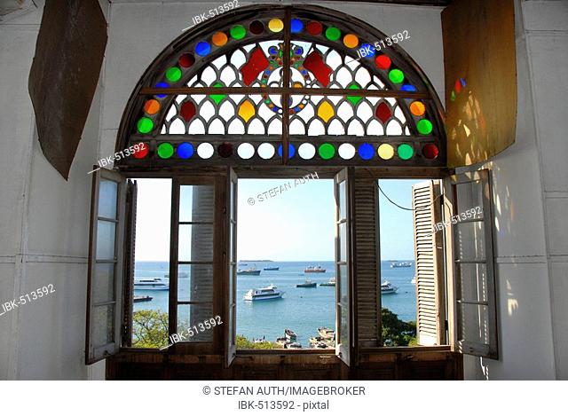 View through colourful open window of Beit el-Sahel Palace Museum to the sea with ships Stone Town Zanzibar Tanzania