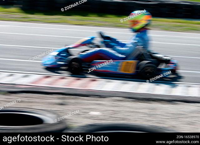 Unrecognised man is driving Go-kart with speed in the on a karting track