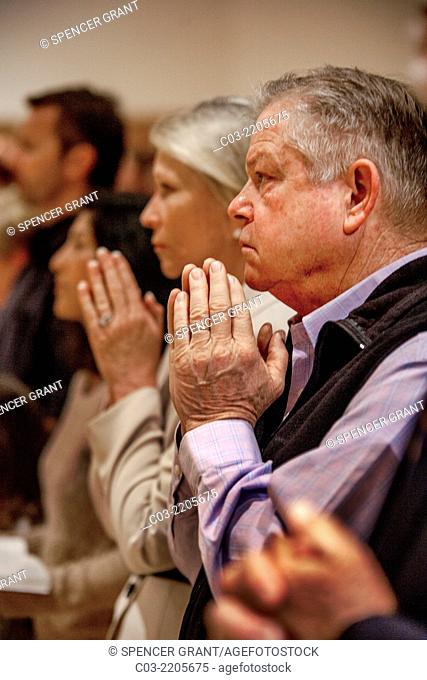 Parishioners hold their hands in prayer during mass at St. Timothy's Catholic Church, Laguna Niguel, CA