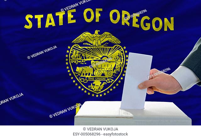 man voting on elections in front of flag US state flag of oregon