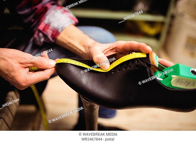 Close up of cobbler measuring a shoe