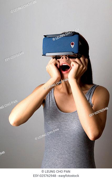 Shocked Woman watching thought thr VR device