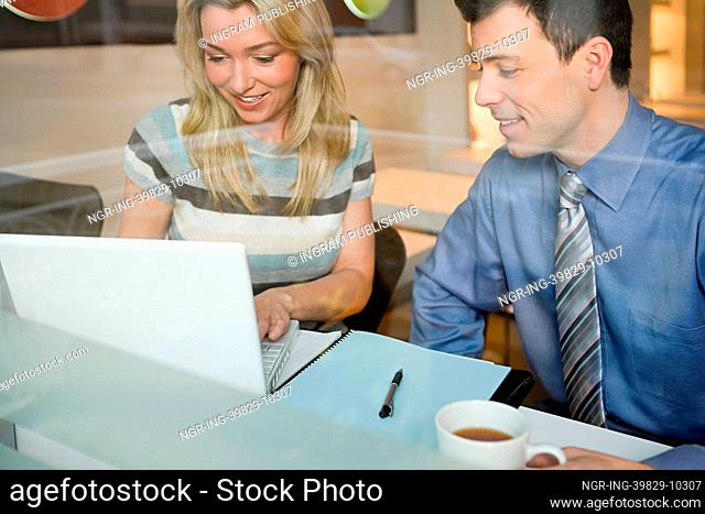 Colleagues in cafe with laptop