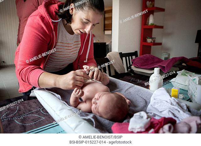 Reportage on an independent midwife during post-partum home visits. The midwife cleans the umbilical cord