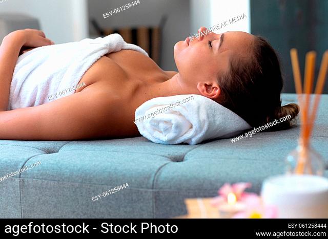 Caucasian young woman in a bathrobe relaxing on the massage table