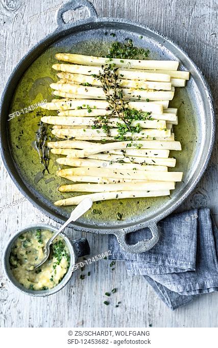 White, oven-baked asparagus with a potato and chive salsa