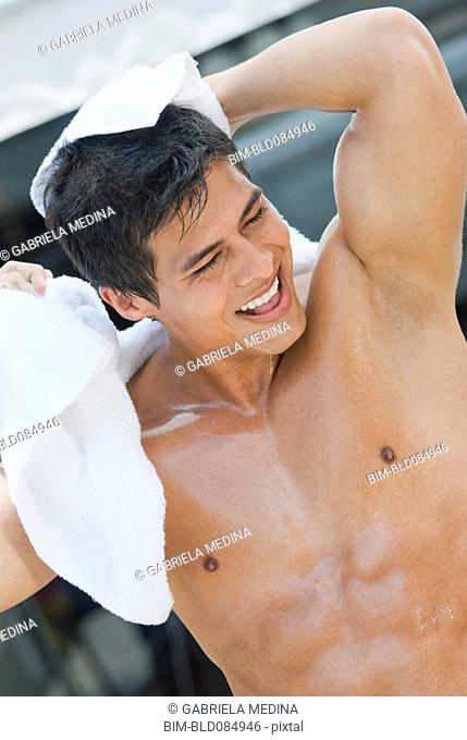 Wet Hispanic man drying off