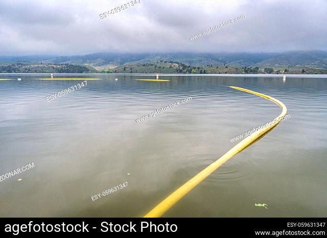 Protected swimming area on a shore of Horsetooth Reservoir in northern Colorado on a foggy, calm summer morning