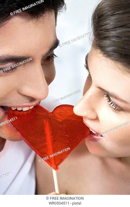 Couple eating heart shaped lollipop