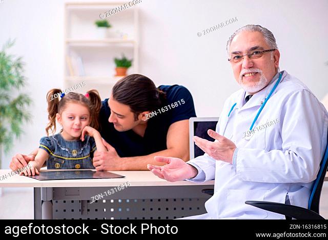 Young father and his daughter visiting old doctor