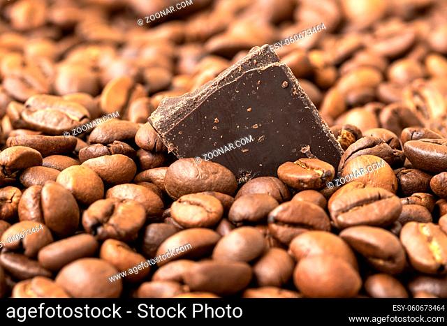 Fresh roasted coffee beans and piece of chocolate