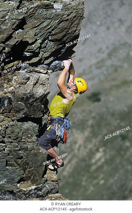 A young man climbing the Cardiac Arete on the Grand Sentinel, Alberta, Canada