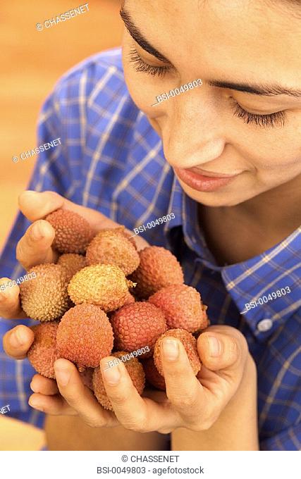 WOMAN EATING FRUIT<BR>Model release.<BR>Litchees