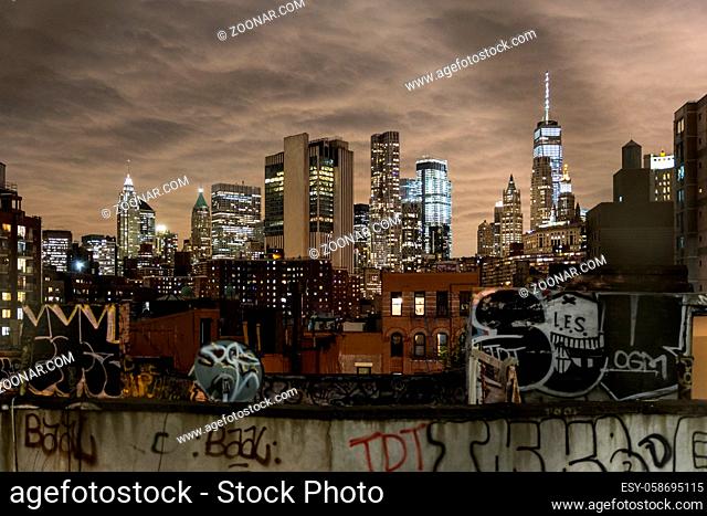 Manhattan bridge view over Chinatown at night, lower Manhattan in the background. New York City, United States of America