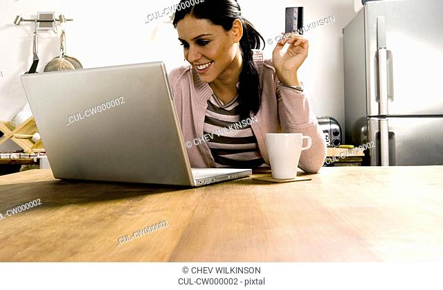 Woman looking at laptop with credit card