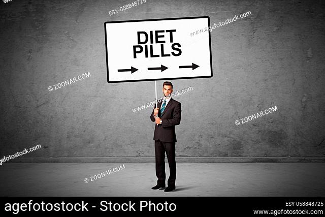 business person holding a traffic sign with DIET PILLS inscription, new idea concept