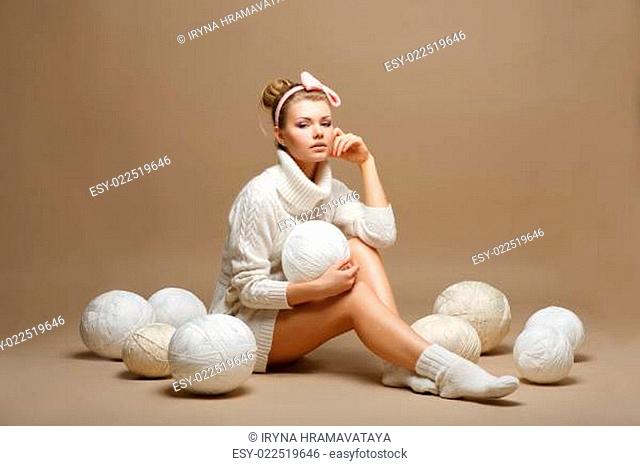Housework. Young Woman in White Tricot with Woolen Balls. Seamstress