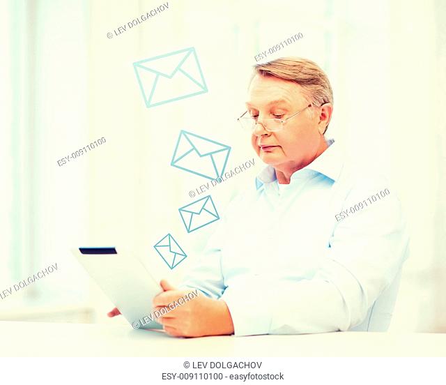 business, office, oldness, school and education concept - old man wearing eyeglasses with tablet computer at home