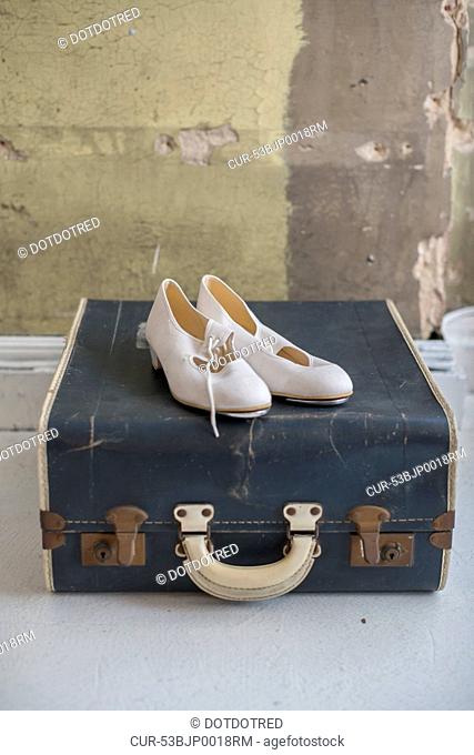 Shoes sitting on antique suitcase