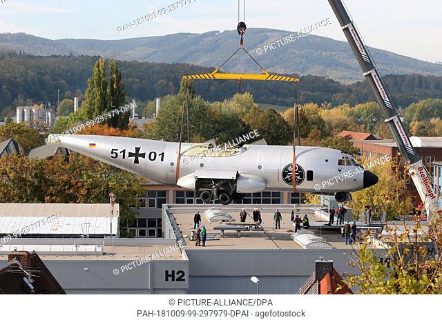 09 October 2018, Saxony-Anhalt, Wernigerode: A Transall is lifted onto the roof of the Luftfahrtmuseum Wernigerode by a crane