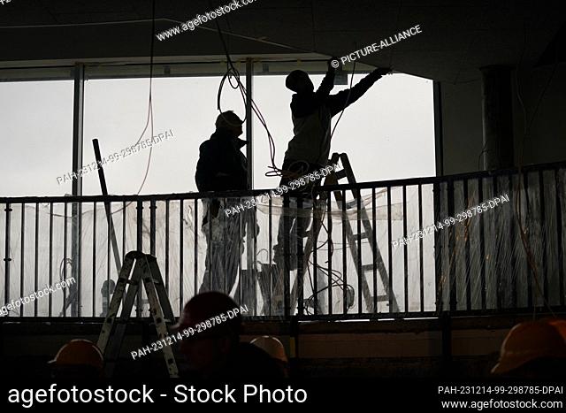 14 December 2023, Hamburg: Construction workers work in one of the former flak towers and future hotel reception during a tour of the greened St