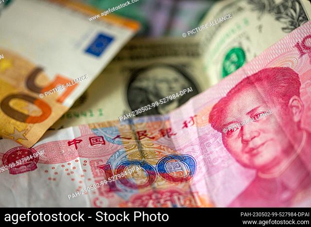 ILLUSTRATION - 27 April 2023, Berlin: A Chinese 100 yuan banknote (front), a 1 U.S. dollar bill (M) and a 50 euro banknote (l) are lying on a table
