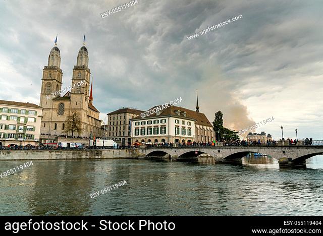 Zurich, ZH / Switzerland - April 8, 2019: Zurich cityscape with many people crossing the river Limmat during the traditional spring festival of Sechselauten in...