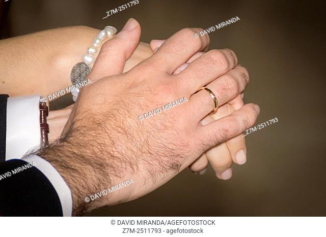 Novios cogidos de la mano en la boda con anillo