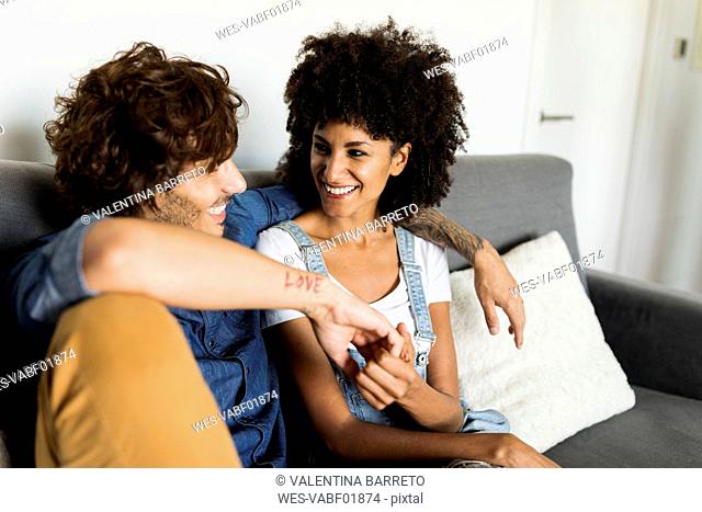 Happy couple sitting on couch talking