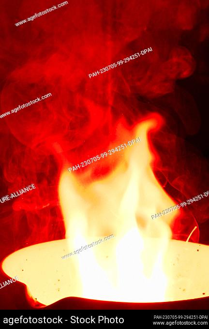 PRODUCTION - 05 July 2023, Saxony-Anhalt, Halle (Saale): A Bengal fire glows red in a chemistry laboratory at Martin Luther University in Halle/Saale