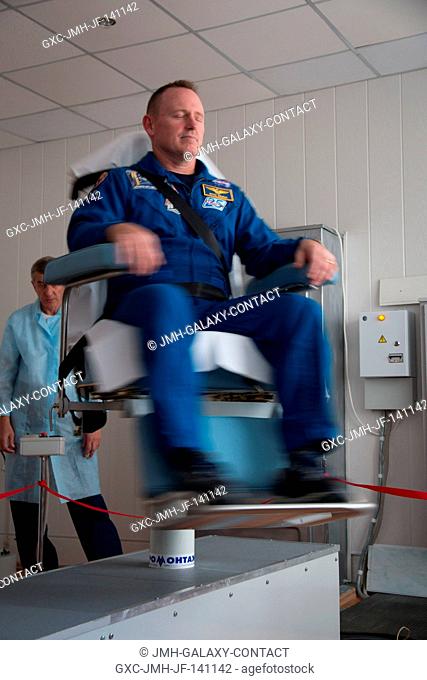 At the Cosmonaut Hotel crew quarters in Baikonur, Kazakhstan, Expedition 41 Flight Engineer Barry Wilmore of NASA takes a turn in a spinning chair to test his...